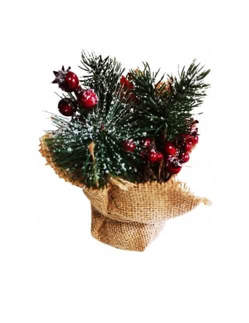 Composición de navidad con bayas rojas y abetos nevados para decoración en maceta de yute