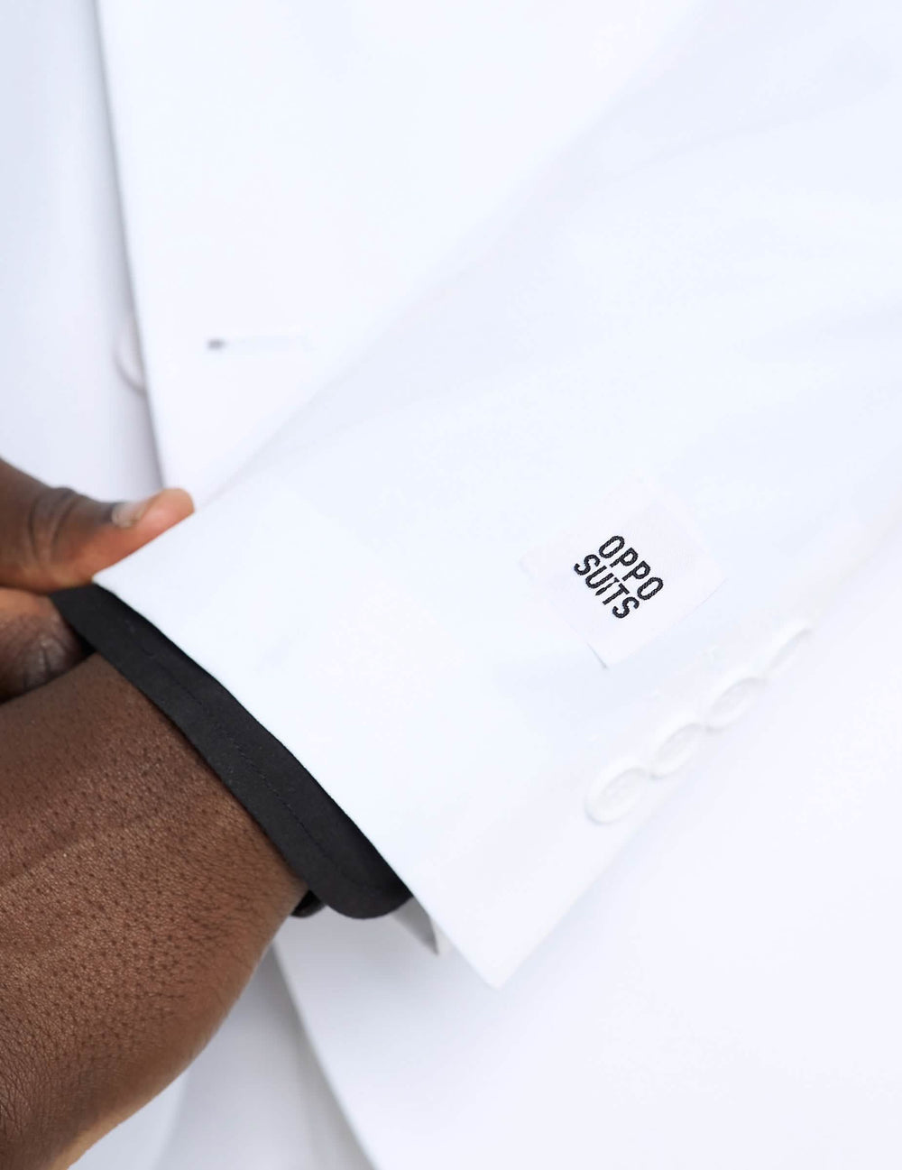 Detalle de la manga y de la etiqueta del disfraz Mr. blanco Opposuits