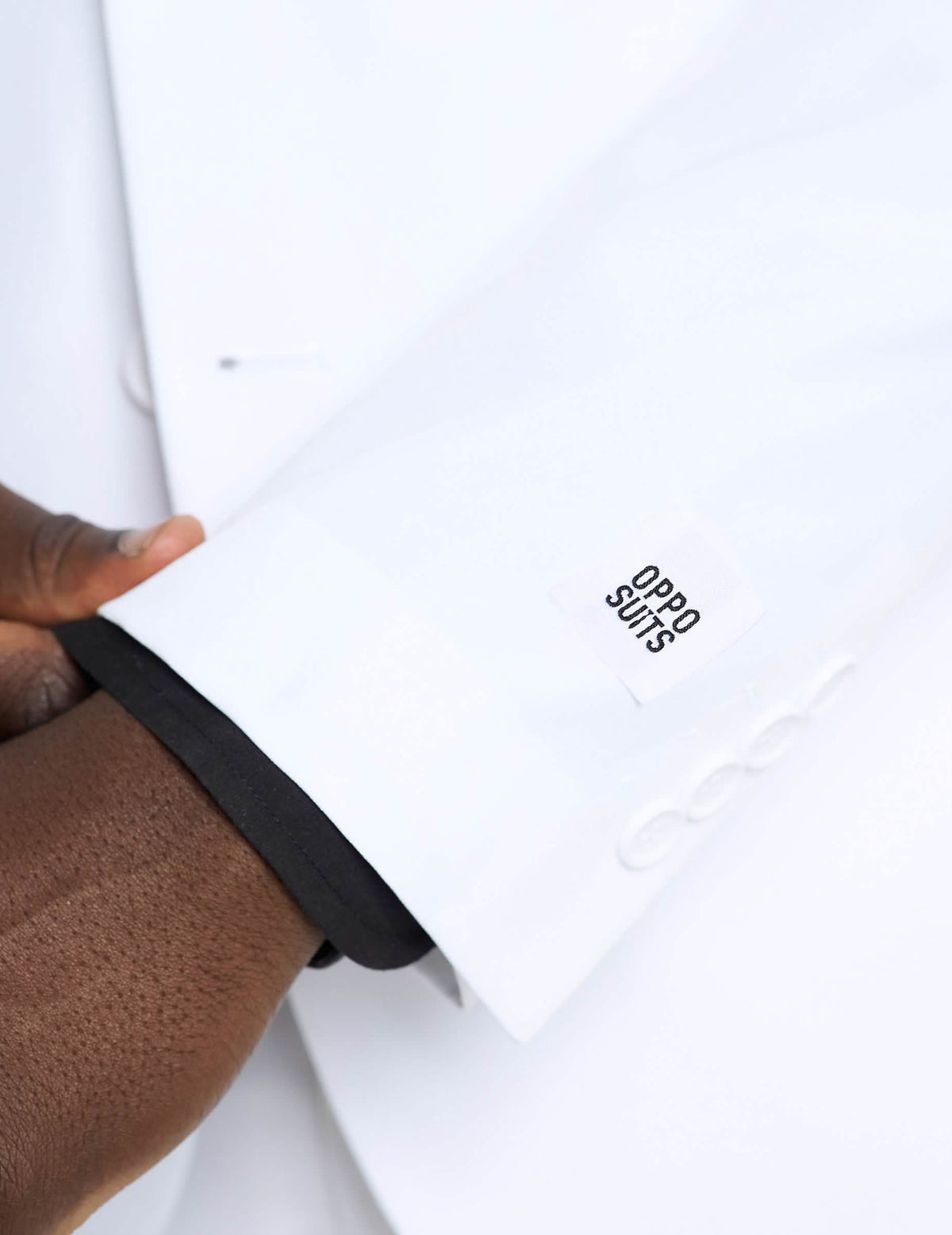 Detalle de la manga y de la etiqueta del disfraz Mr. blanco Opposuits