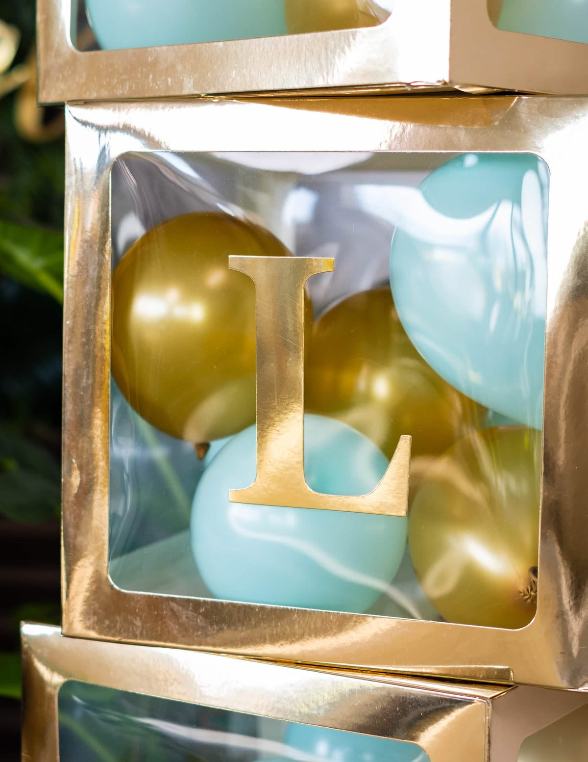 Primer plano de la letra l del cubo con globos transparente para fiesta dorado personalizable