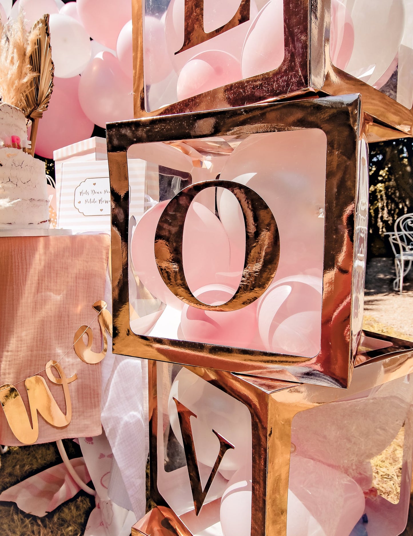Gros plan sur la lettre O du cube à ballons transparent à personnaliser pour décoration de fête rose gold