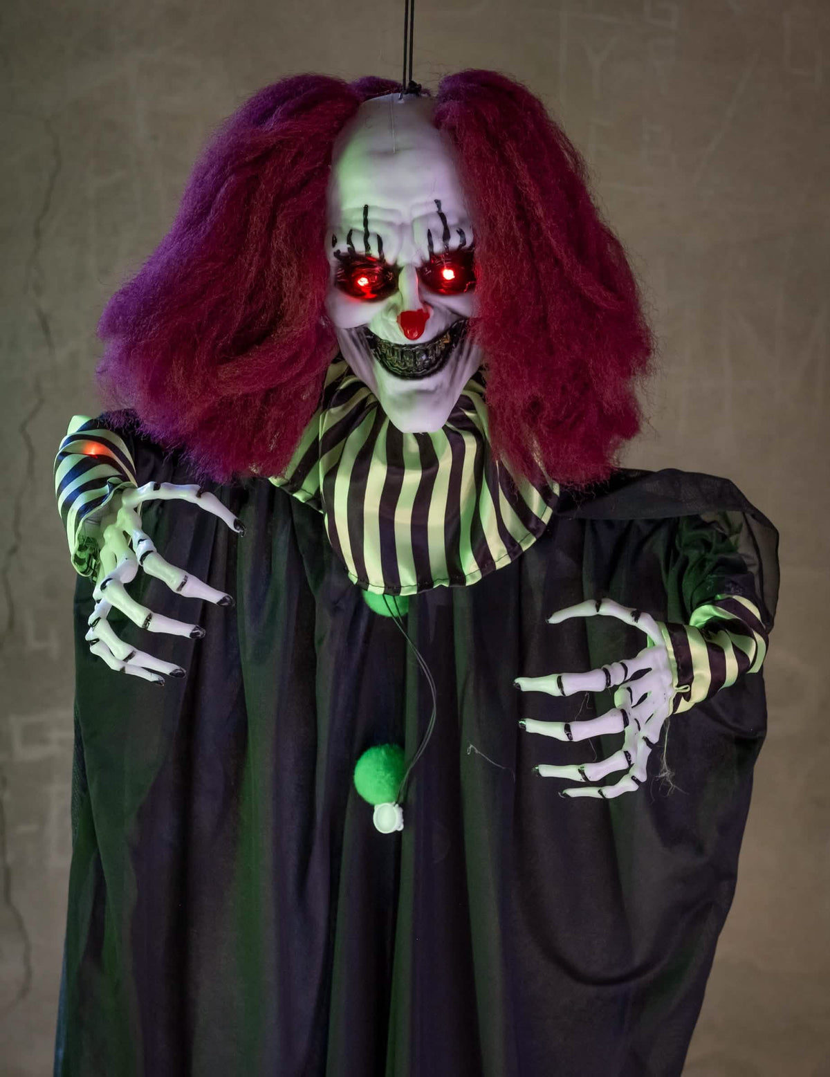 Détail des yeux rouges lumineux et des mains de la Décoration animée Clown Terrifiant