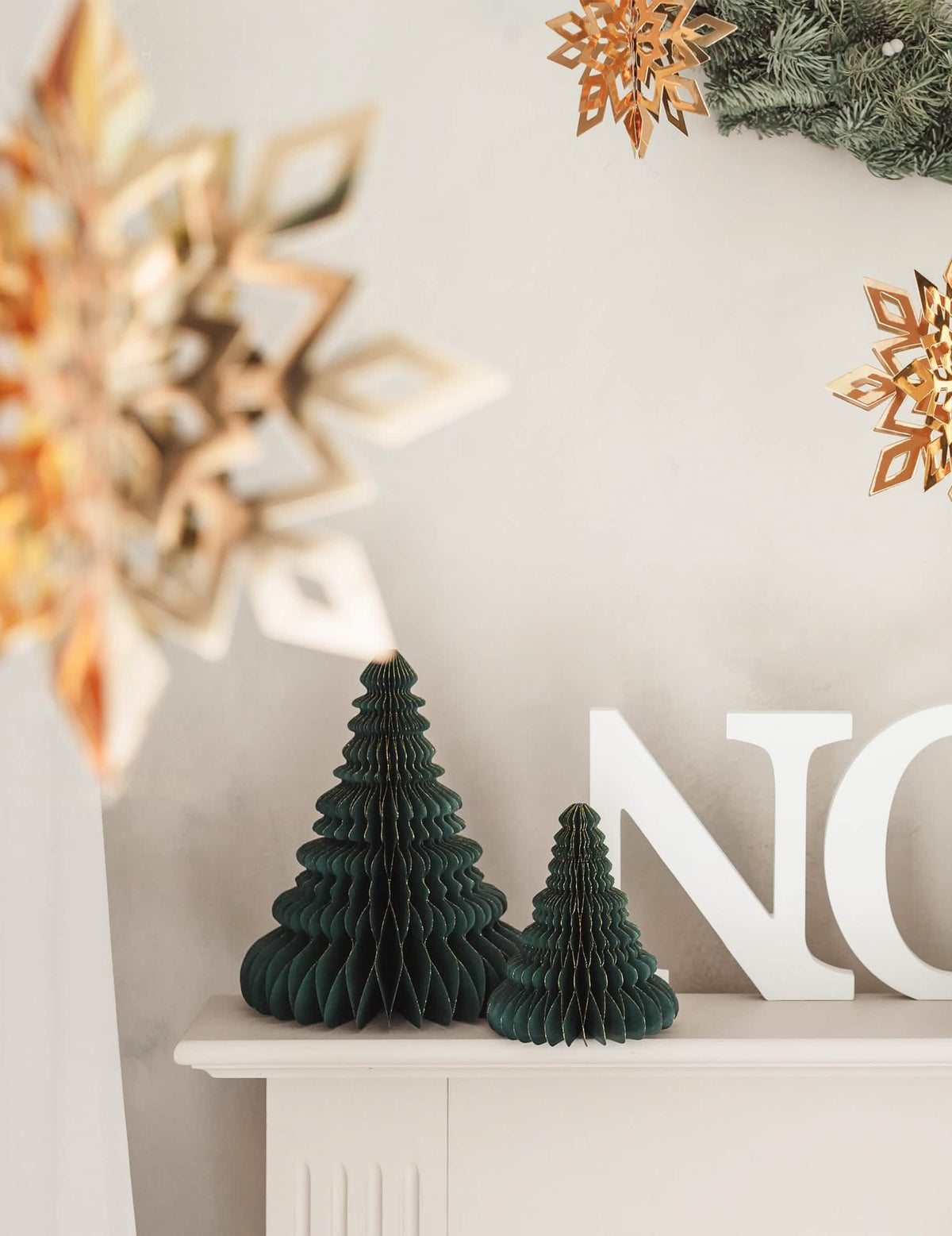 Mise en scène avec lettres et flocons de la décoration en papier alvéolé sapin de Noël
