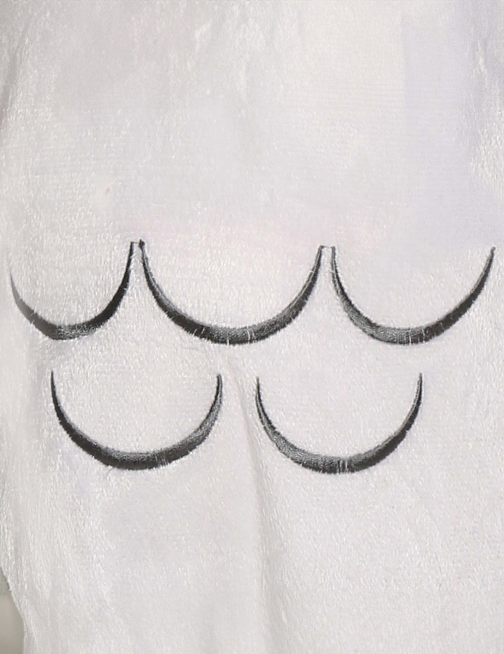 Gros plan sur les motifs de plumes du déguisement chouette magique pour bébé