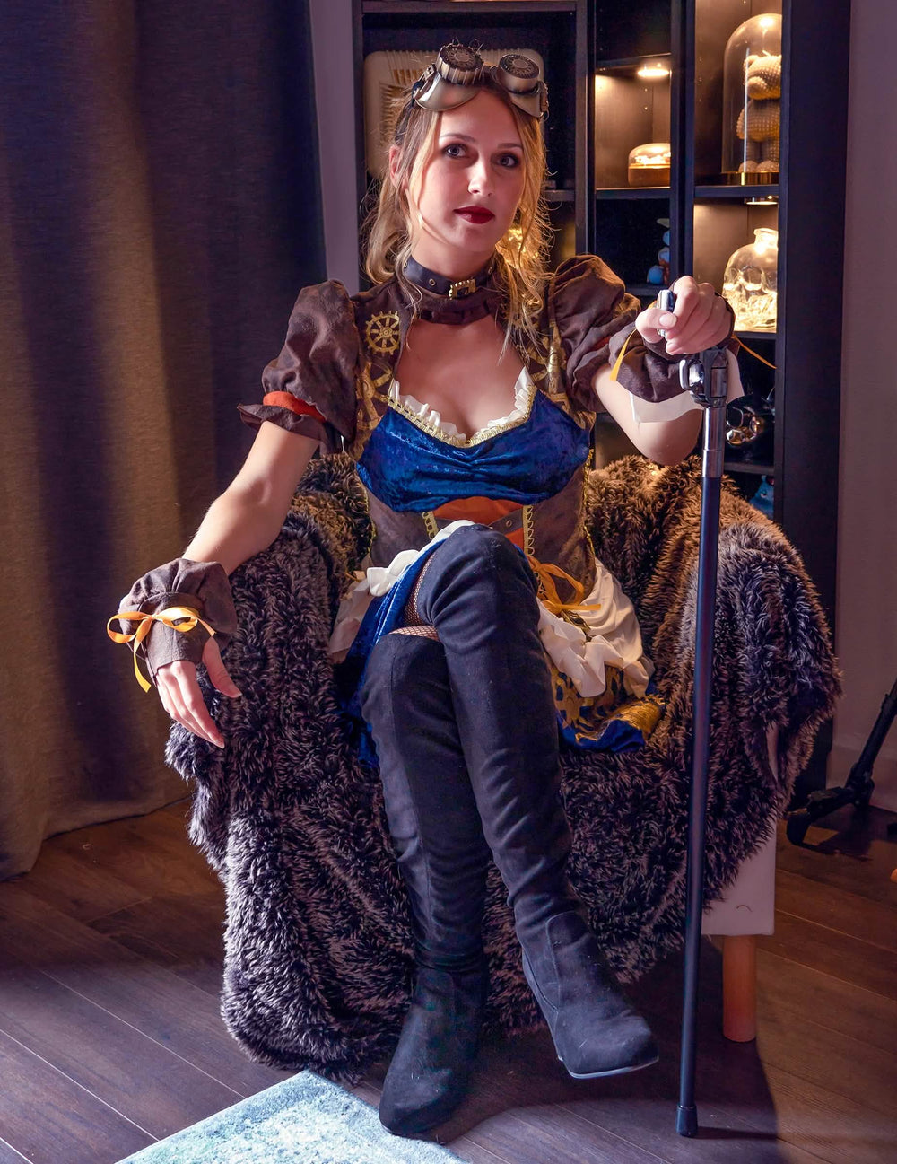 Vista frontal del modelo sentado con accesorios del disfraz retro futurista steampunk