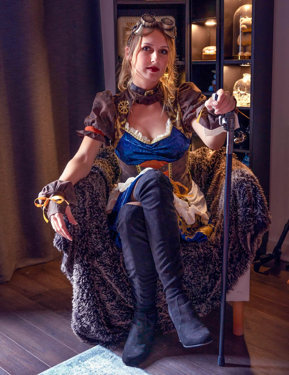 Vista frontal del modelo sentado con accesorios del disfraz retro futurista steampunk