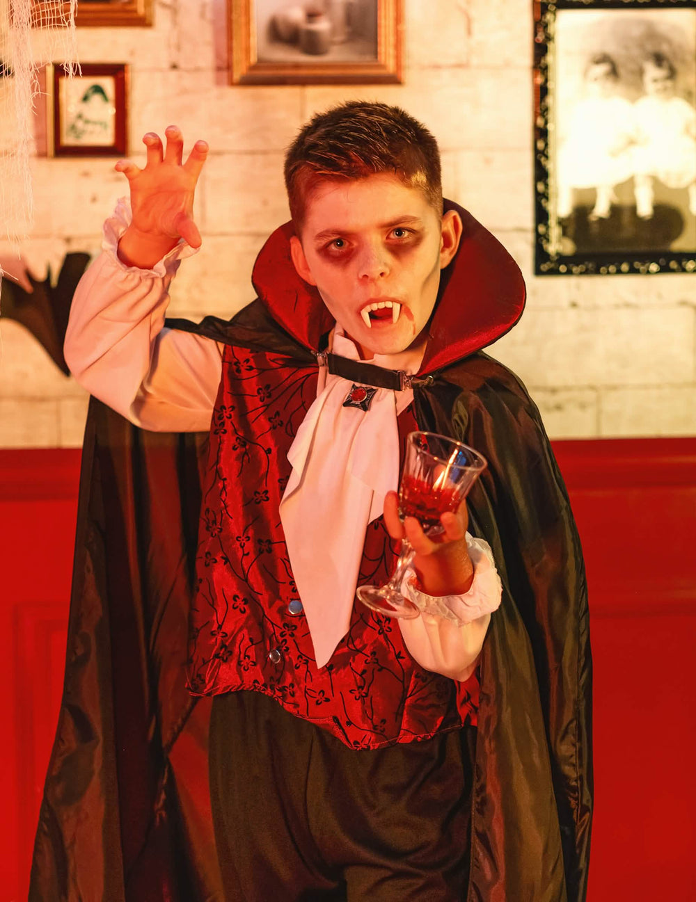 Escenificación con dientes de vampiro y copa del disfraz de vampiro elegante para niño
