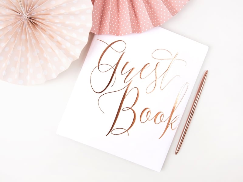 Mise en situation avec stylo et rosaces du guest book pour mariage blanc et rose gold