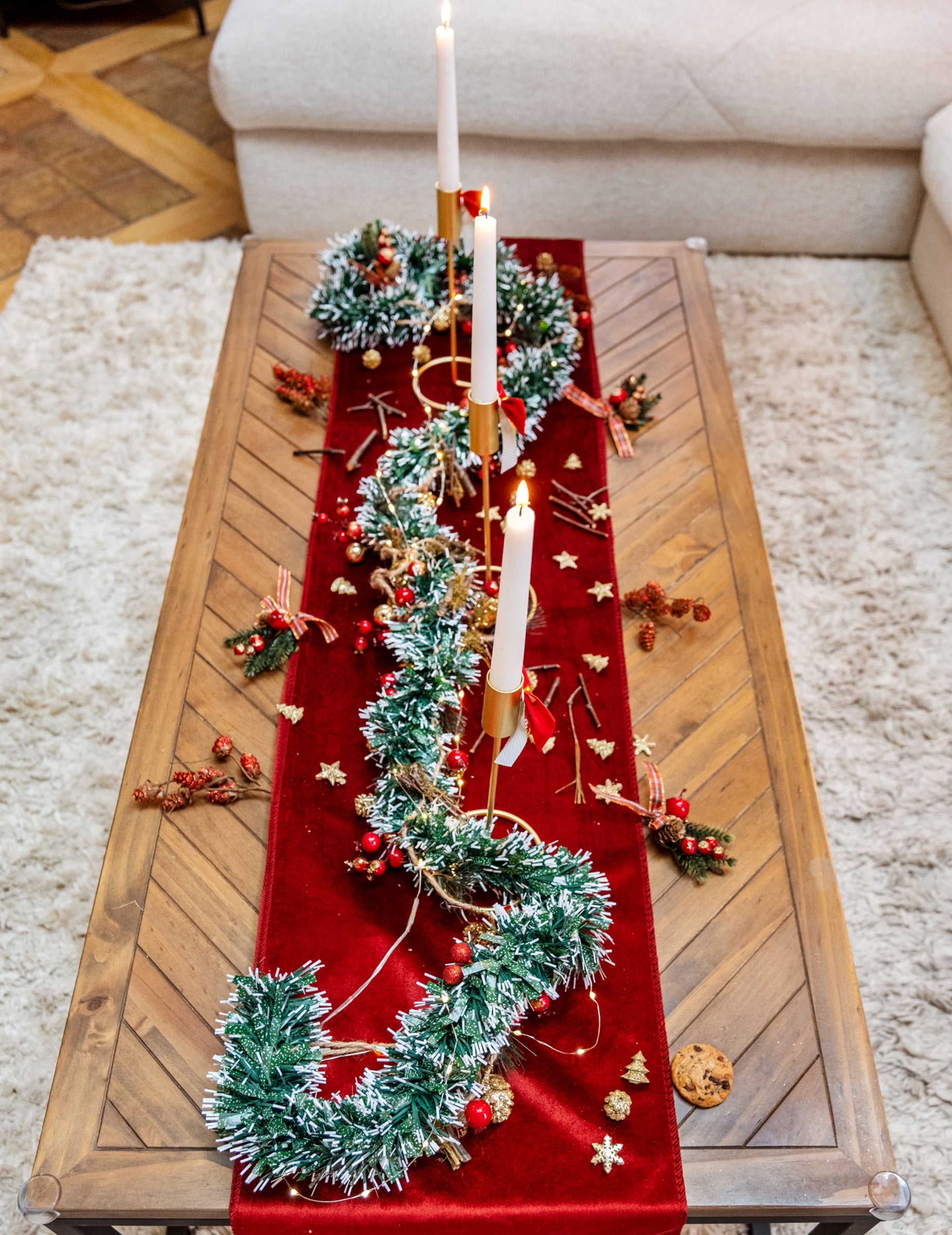 Mise en scène avec bougies de la guirlande de sapin enneigée avec baies