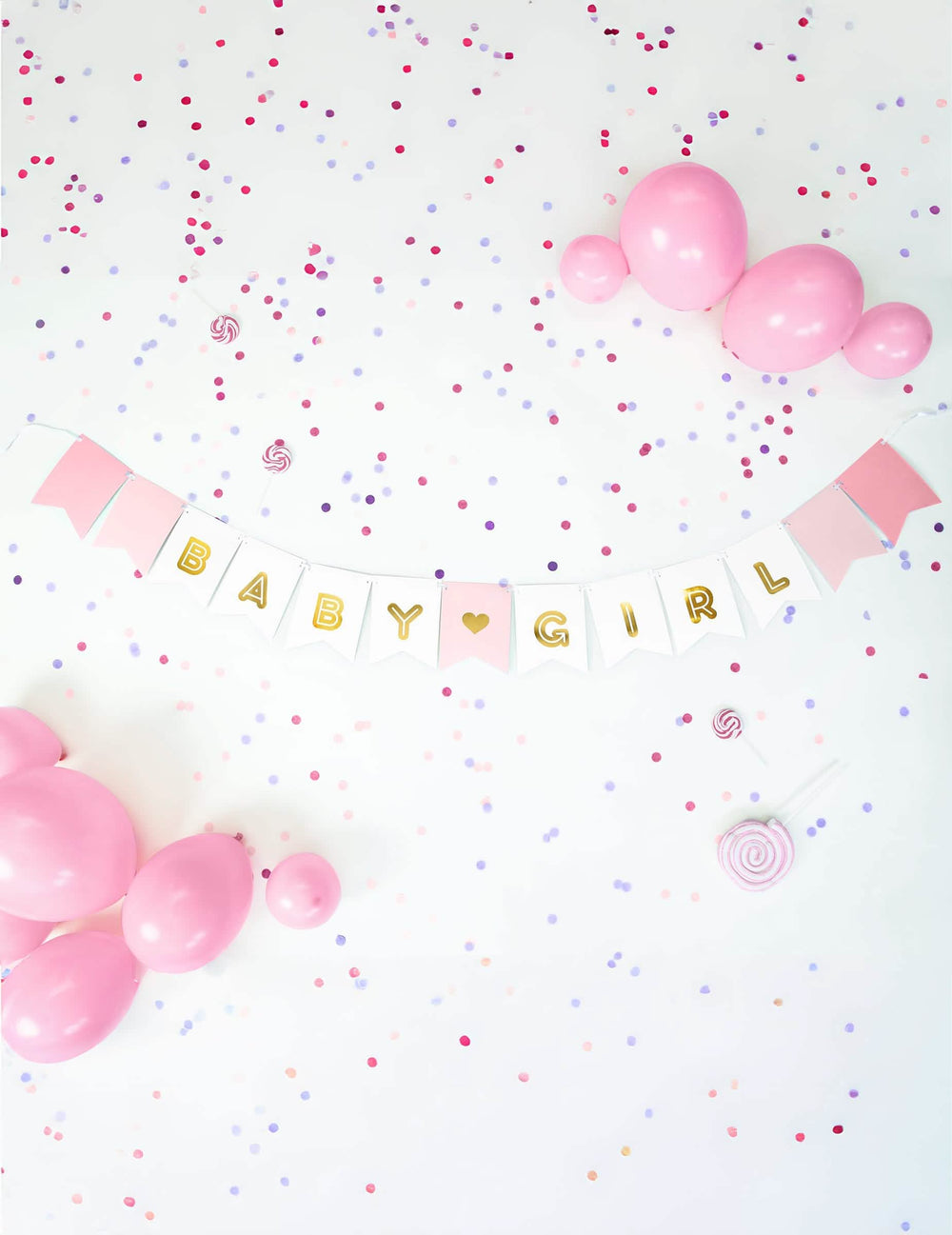 Mise en situation avec ballons et confettis de la guirlande en carton baby girl pour baby shower