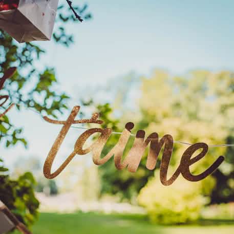 Gros plan sur les paillettes de la guirlande en carton je t'aime à la folie