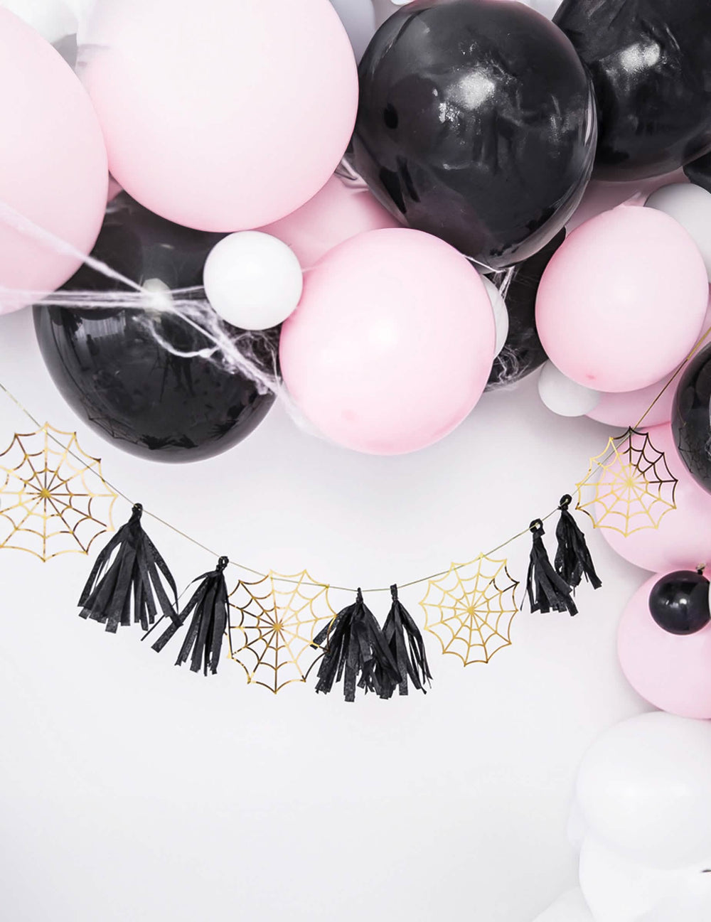 Detalle de los tejidos dorados y de las borlas de la guirnalda de papel con borlas de telaraña para fiesta