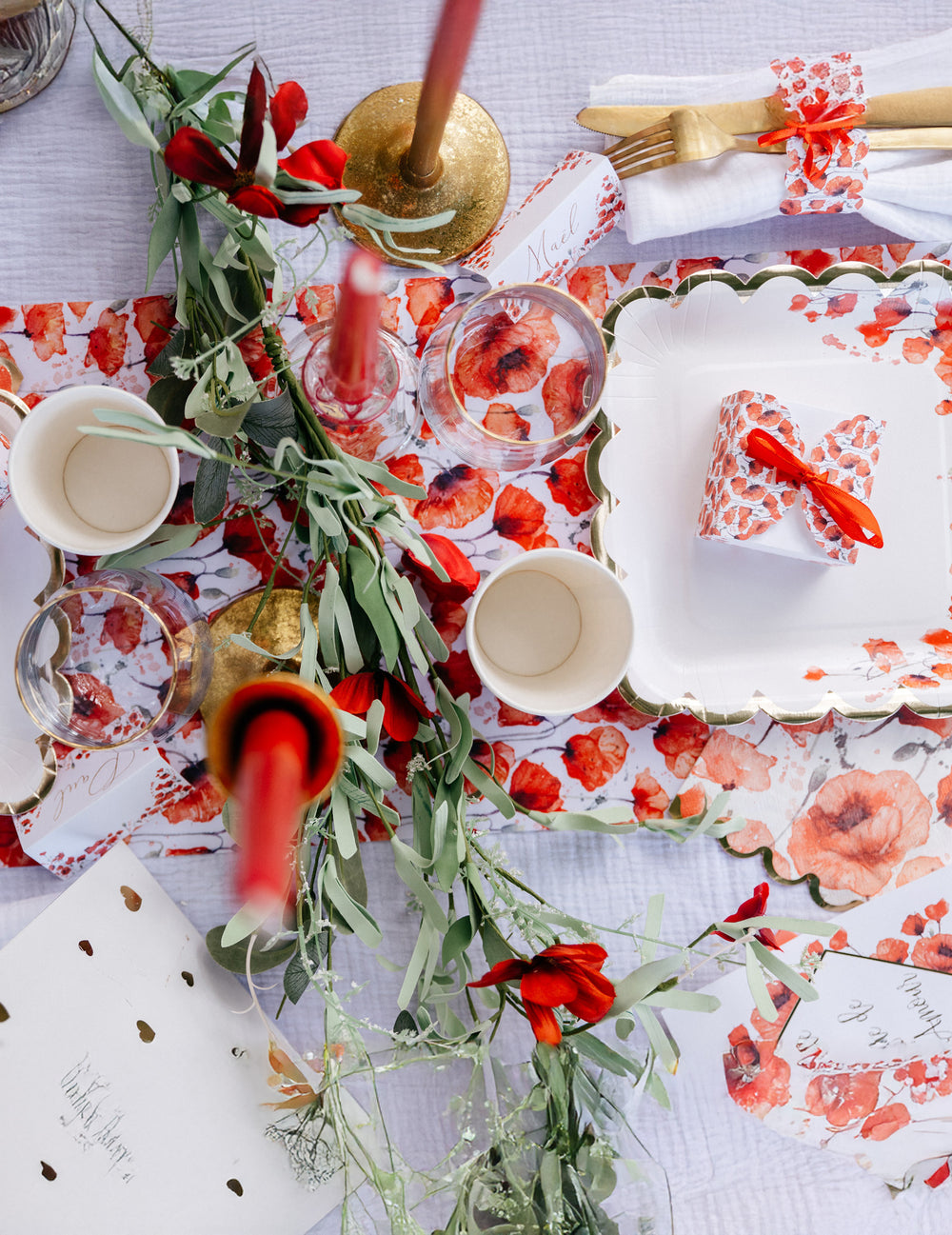 Mise en situation sur une table de la guirlande style champêtre feuillages et fleurs rouges
