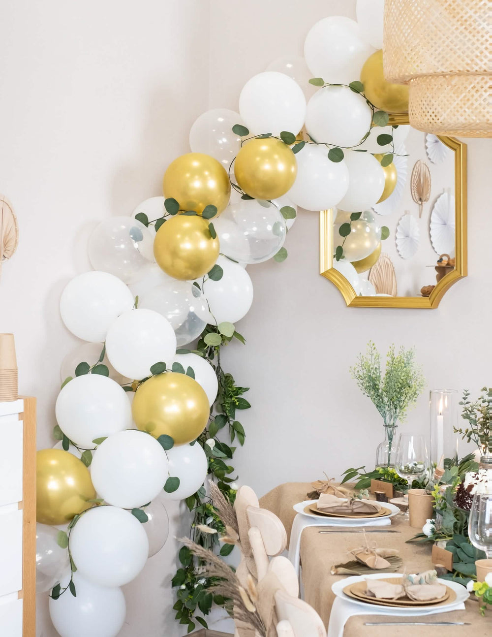 Puesta en situación del kit de arco de 60 globos blancos y dorado con eucalipto vegetal