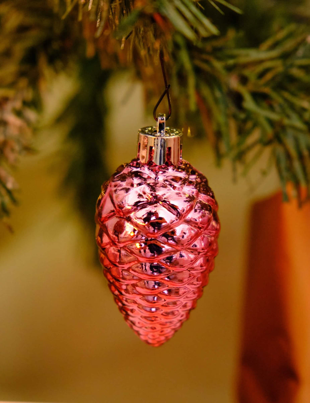 Primer plano de una piña brillante del kit de decoraciones para árbol oro rosa