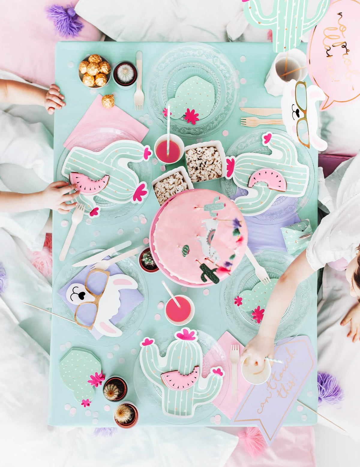 Mise en situación sobre una mesa de fiesta del kit photocall llama pastel 5 piezas para cumpleaños