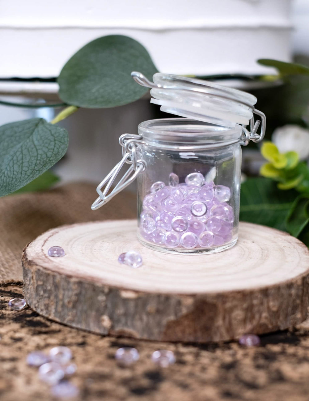 Gros plan sur le bocal sur rondin de bois des perles effet goutte de pluie pour décoration de table parme