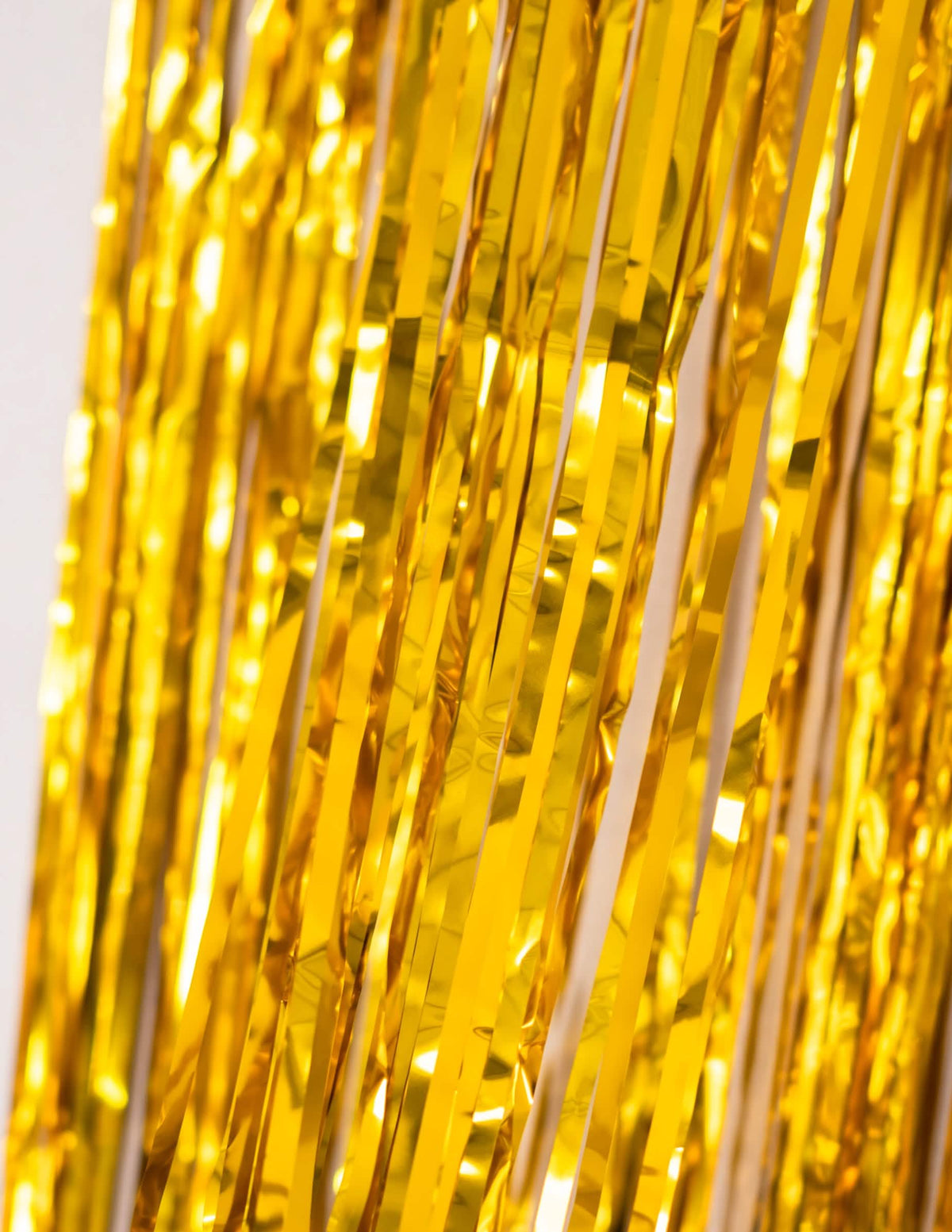 Détail de la brillance des bandes dorées du rideau scintillant pour décoration de fête